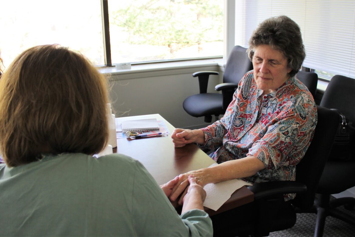 Hospice of the Chesapeake Volunteers practice Compassionate Touch, an integrative arts technique used to comfort patients, during a training session.