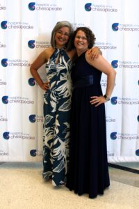 Fashion for a Cause: Guests stopped by the step and repeat backdrop for a photo op. From left: Monica Escalante, who will be Hospice of the Chesapeake’s Chief Strategy and Information Officer in August, and Director of Education and Emergency Management Elisabeth Smith. Photo by Briana Banks