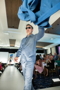 Fashion for a Cause: Kevin Campion, one of the 33 community models showing off great looks from top Annapolis clothiers, tosses a robe into the audience. Photo by Mike B. Photography