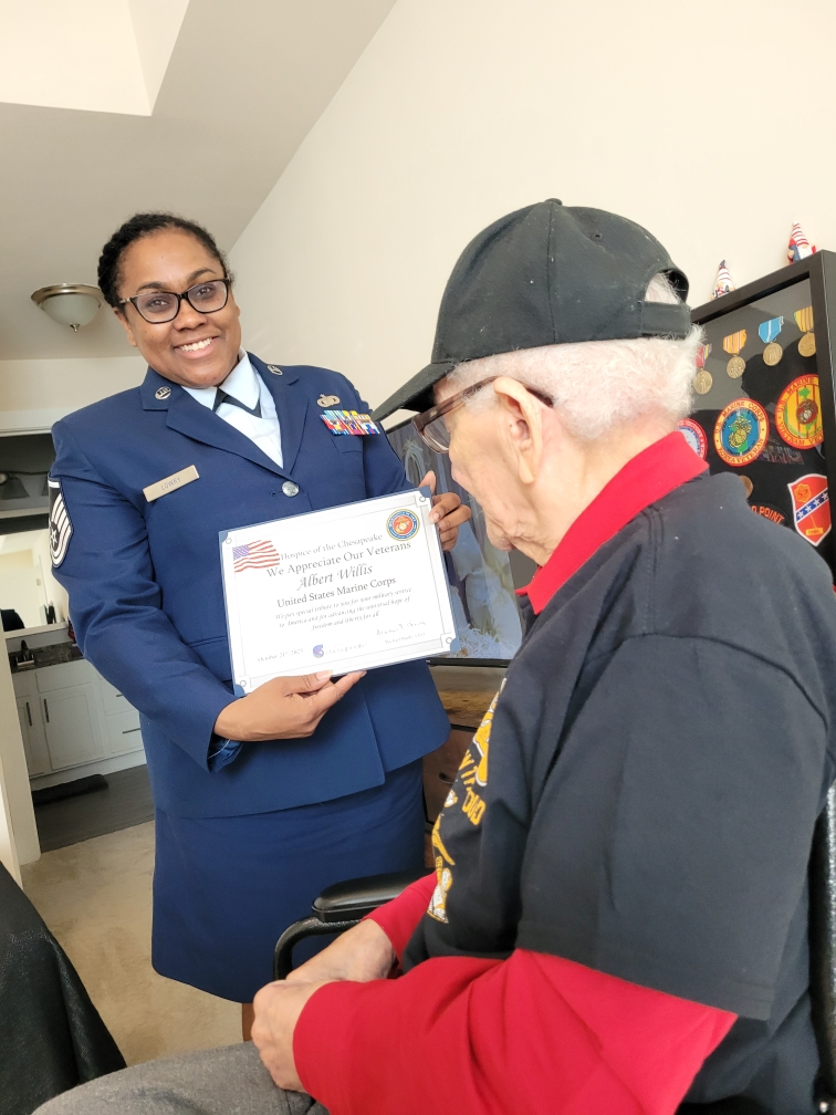 Marine Corps veteran Albert Willis is presented with a certificate of appreciation for his military service from Hospice of the Chesapeake volunteer Air Force Master Sgt. Akesha Lowry during his honor salute.